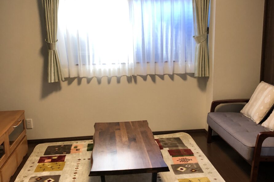 FunHome名古屋城 リビング。ソファと木のローテーブルが置かれた居間