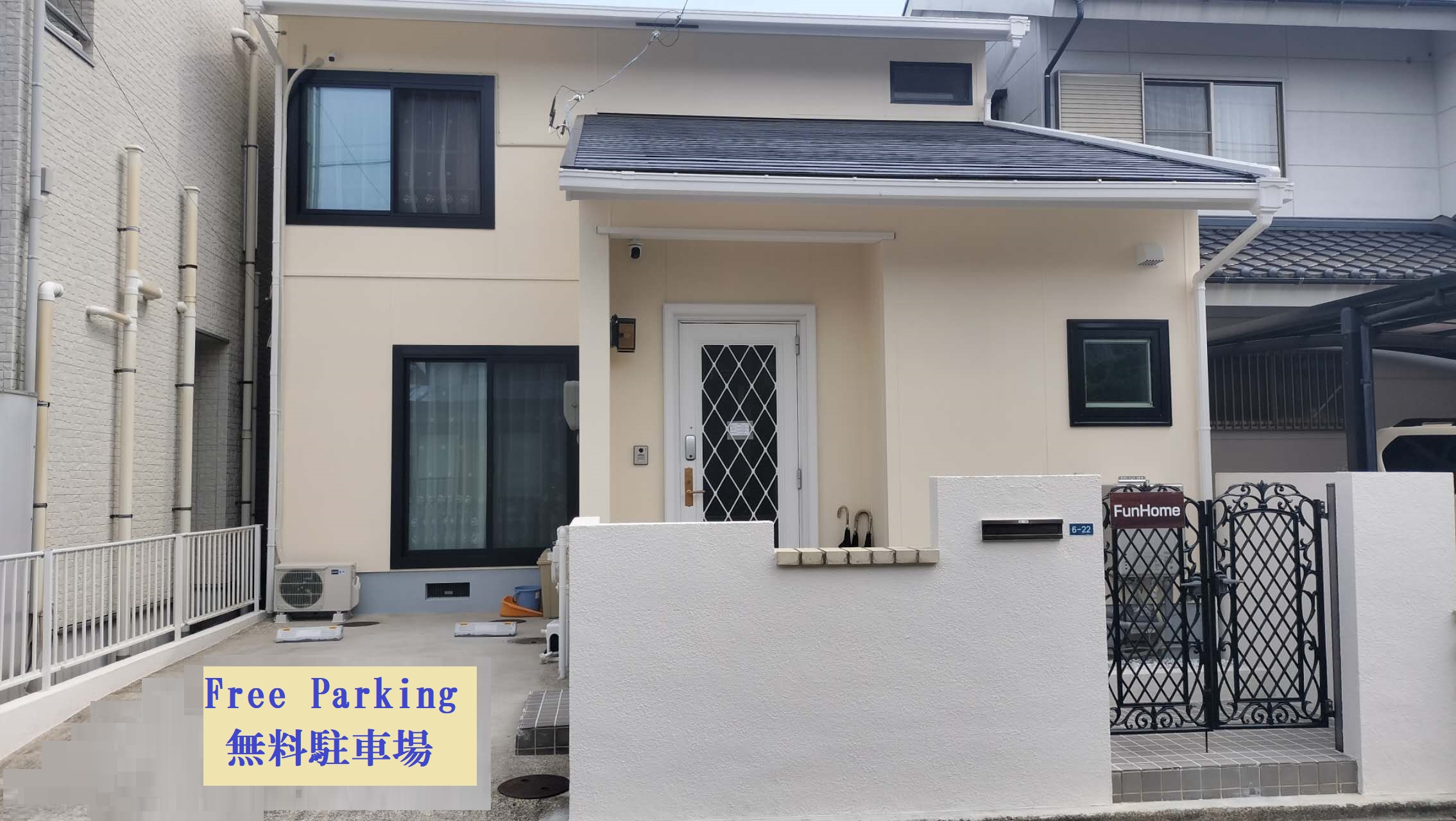 FunHomeの建物の外観と門。手前に「Free Parking 無料駐車場」の看板
